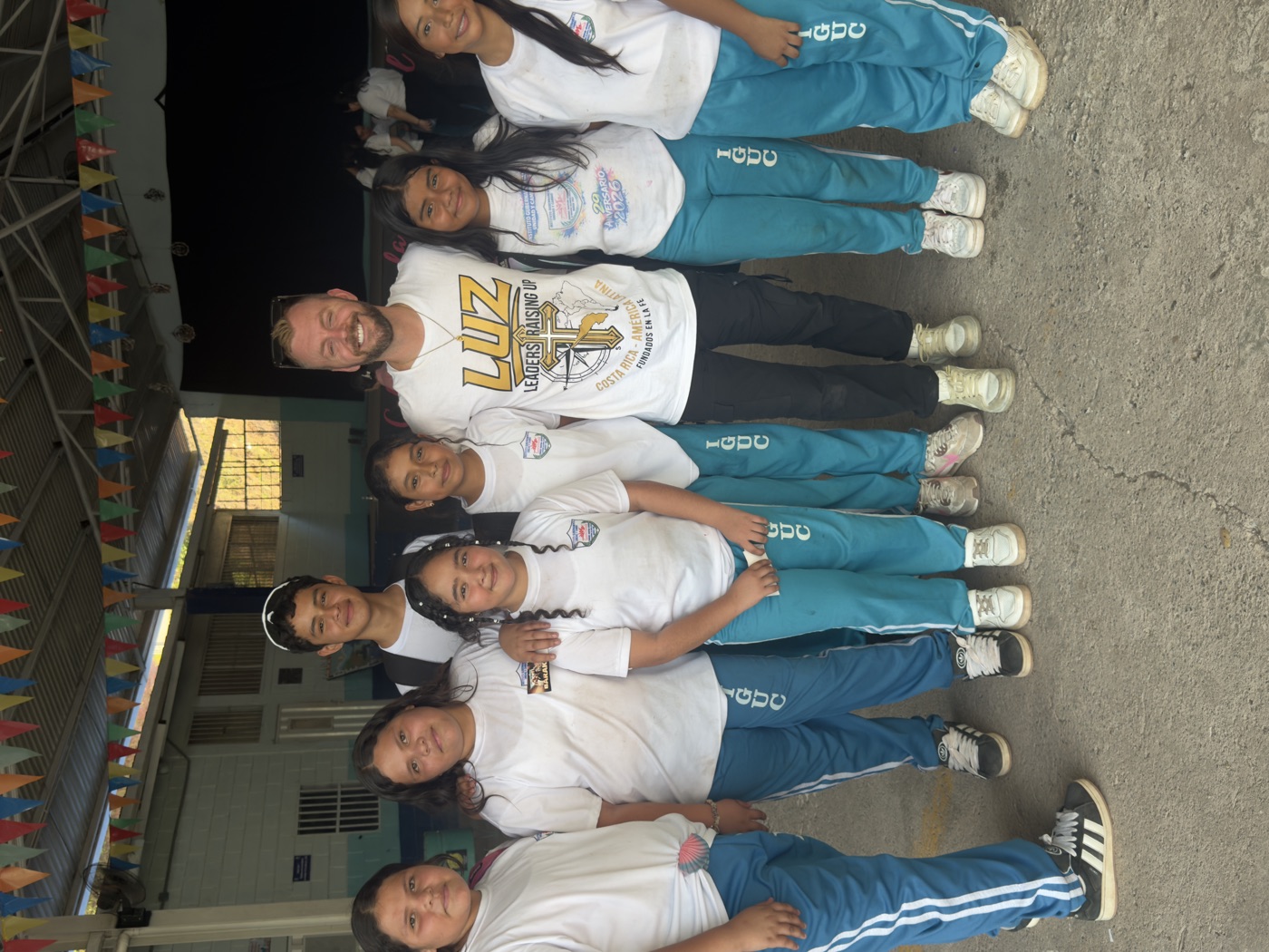 Grupo de estudiantes con un líder de LUZ Impacto tras un evento en su colegio